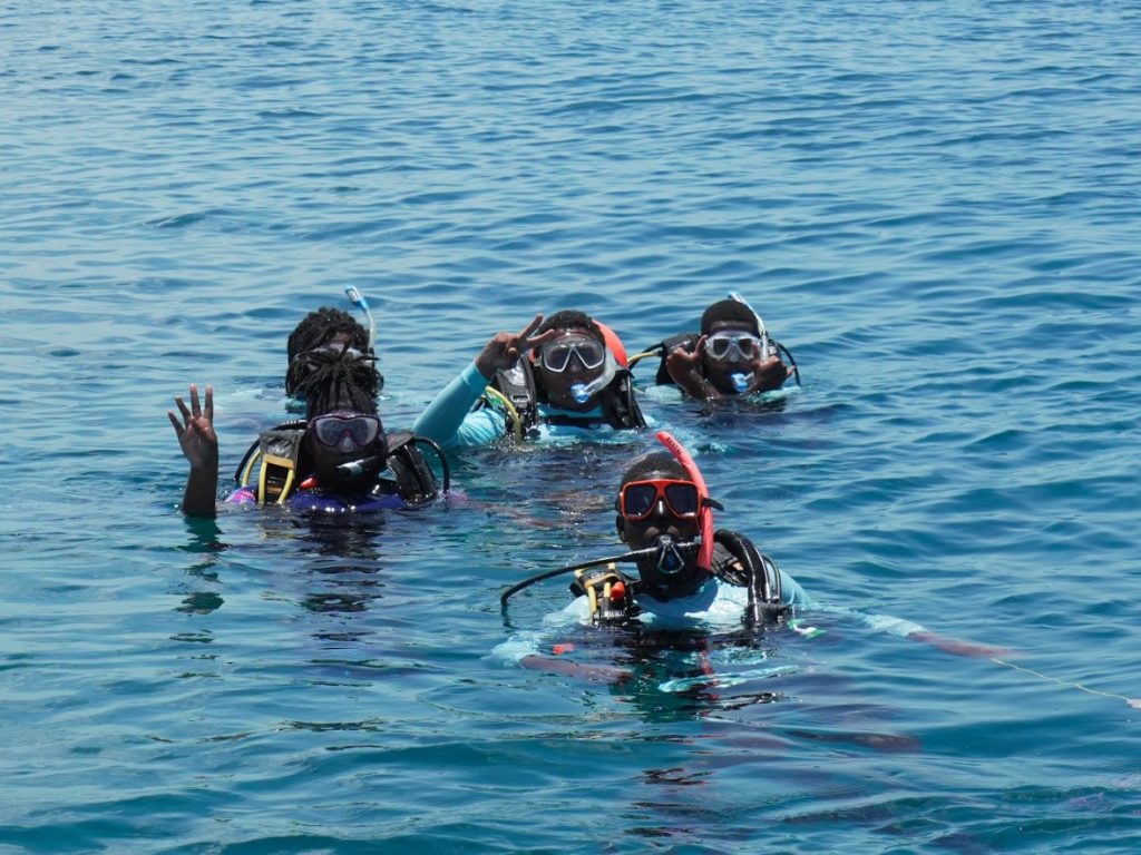 Rising Tides students surface after completing one of their first dives, beaming with excitement and pride.