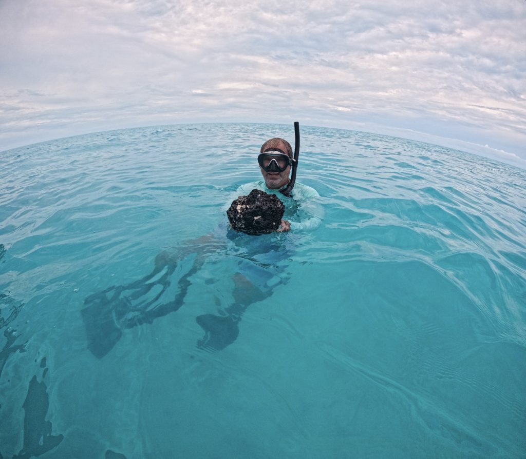 Dr. Craig Dahlgren surfaces with a sponge specimen in hand after a successful survey in Andros West Side National Park.